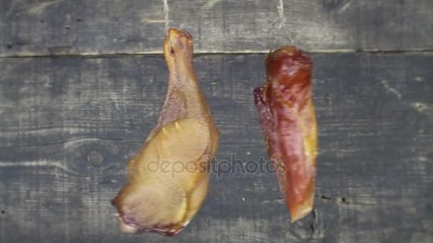 Uzené maso visí a kymácející dřevěné pozadí — Stock video