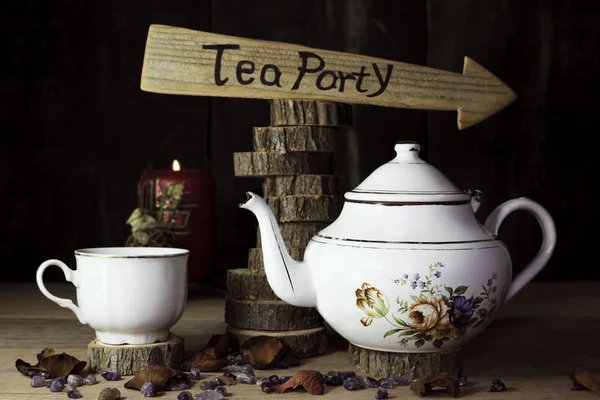 Fiesta del té. Taza de té y tetera en la mesa de madera con el signo de flecha en el fondo — Foto de Stock