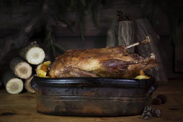 Christmas Duck Roast At The Wooden Table With Wood Logs and Pine Branches In The Background — Stock Photo, Image