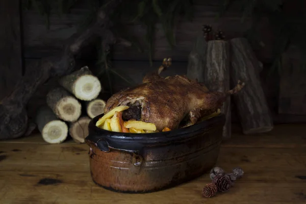 Christmas Duck Roast At The Wooden Table With Wood Logs and Pine Branches In The Background — Stock Photo, Image