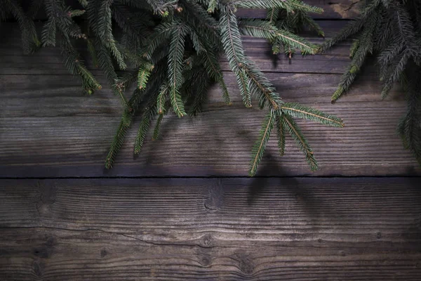 Çamın dalları karşı rustik ahşap kurulları ile Noel arka plan — Stok fotoğraf