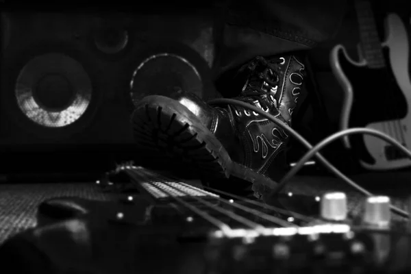战斗靴踩在低音吉他上。坚硬岩石和重金属概念 — 图库照片