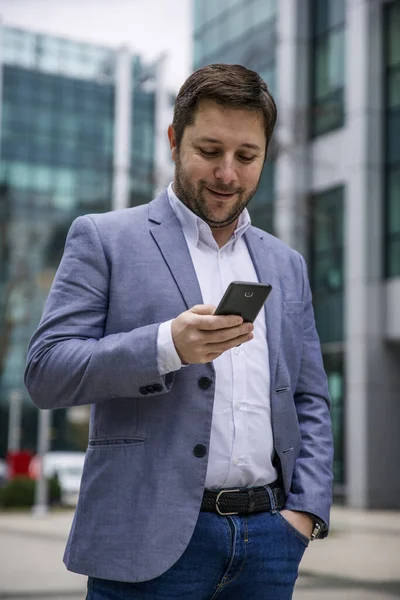 Biznesmen Korzystający Smartfona Zewnątrz Przed Budynkiem Biurowym Sms Sms Surfing — Zdjęcie stockowe