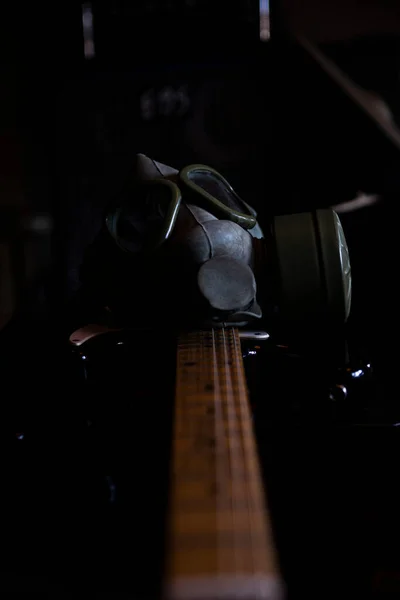暗い環境で電気ギターの軍用ガスマスク コロナウイルスCovid19パンデミック予防 バイオハザード 感染症の危険性 黙示録的な音楽学の概念 — ストック写真