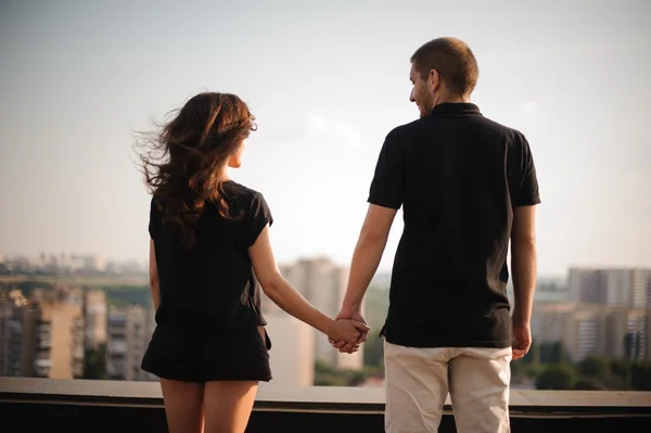 Paret bakom hålla händerna tittar på staden — Stockfoto