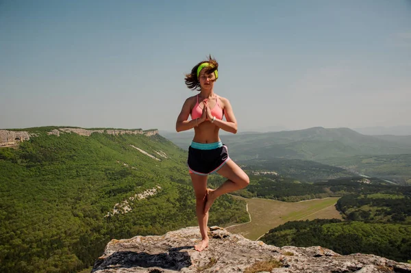 Meisje houdt zich bezig met yoga op de top van berg. gezonde manier van leven. — Stockfoto