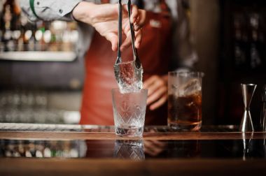 Profesyonel bir barmen bir buz tutuyor.