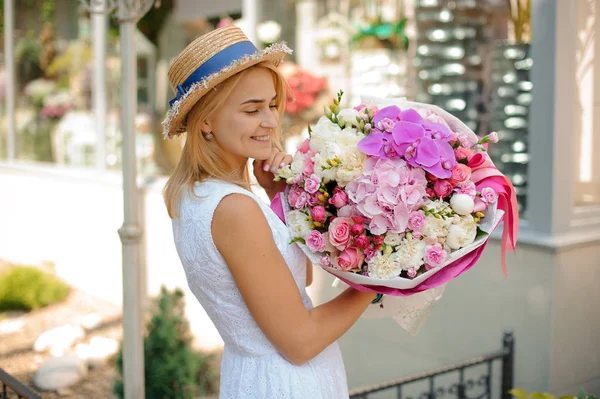 Hermoso ramo de flores mixtas celebrar por la mujer sonriente — Foto de Stock