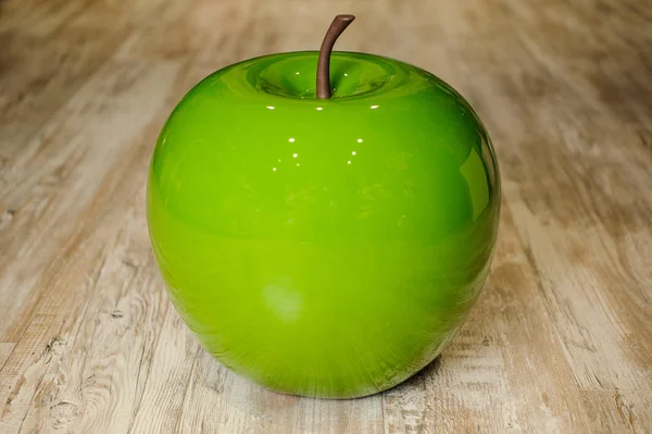 Plastic green apple on a wooden background — Stock Photo, Image