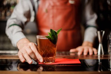 Barmen bir kokteyl nane ile elinde tutuyor.