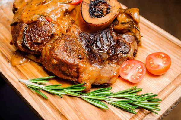 Sıcak ızgara yedek kaburga bir ahşap kesme tahtası üzerinde taze domates ile