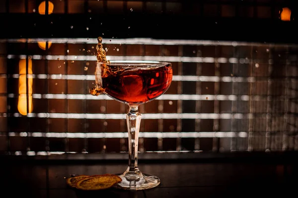 Red martini cocktail splashing into glass on dark background — Stock Photo, Image