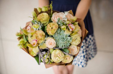 Bir küçük yeşil buket çiçek elinde tutan kadın