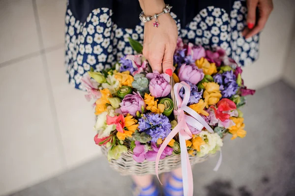Donna che tiene in mano grazioso cesto di vimini di fiori colorati — Foto Stock