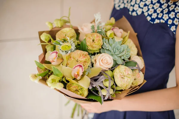 Florist holding a small green bouquet of flowers in hands — Stock Photo, Image