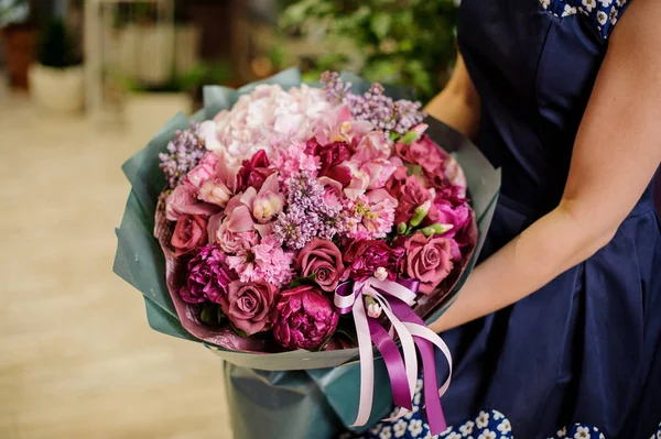 Mulher segurando uma composição bonita e macia de flores — Fotografia de Stock