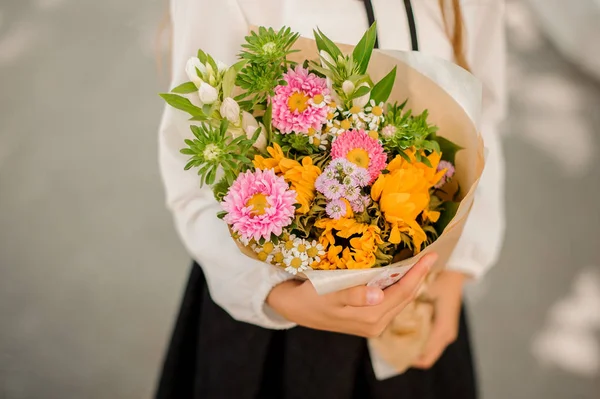 Школярка тримає маленький гарний букет квітів — стокове фото