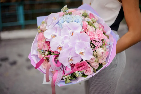 Mãos com uma composição rosa bonita e doce de flores — Fotografia de Stock