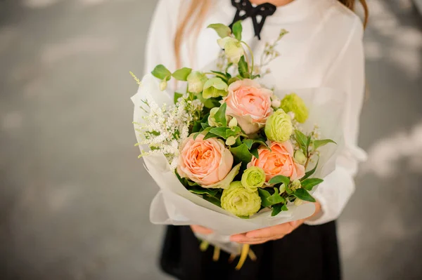 Schoolgirl holding a little bouquet of flowers — Stock Photo, Image