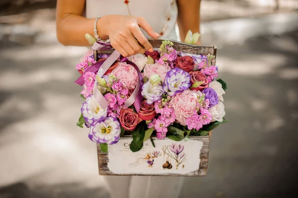 Woman hands holding a lovely composition of flowers — Stock Photo, Image