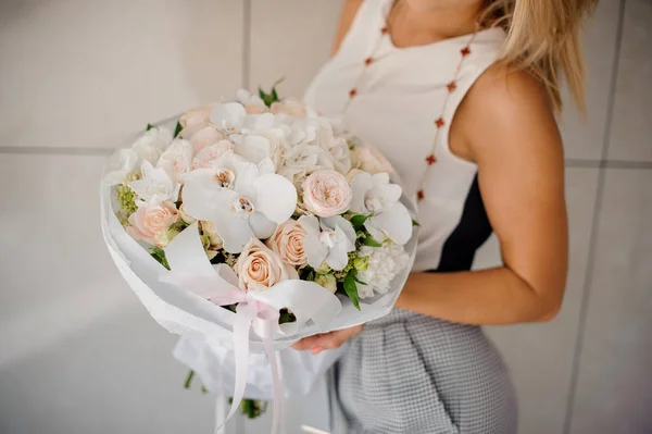 Femme en robe tenant une composition de fleurs — Photo
