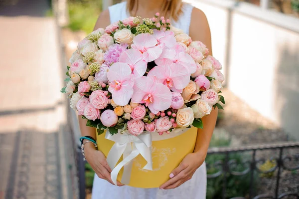 Mãos de mulher com uma bela composição rosa de flores — Fotografia de Stock