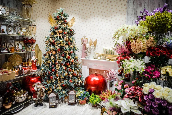 Een grote heldere kerstboom die versierd met kleurrijke slingers en ballonnen. — Stockfoto