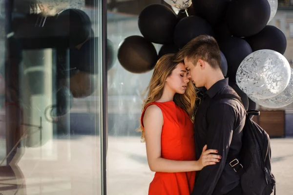 Happy couple in love with black balloons — Stock Photo, Image