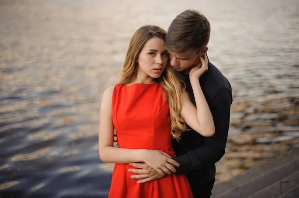 Young and beautiful couple in love on the background of water — Stock Photo, Image