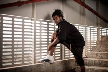 Afro Amerikalı adam yükseltilmiş bacak holding