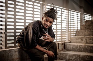 Pencerenin oturan çekici afro Amerikan adam