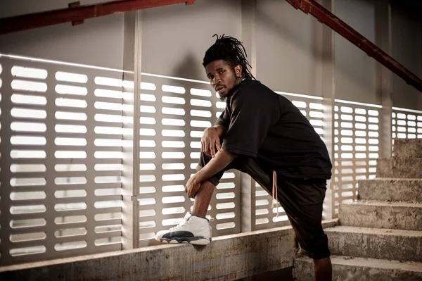 Afro Amerikalı adam yükseltilmiş bacak holding