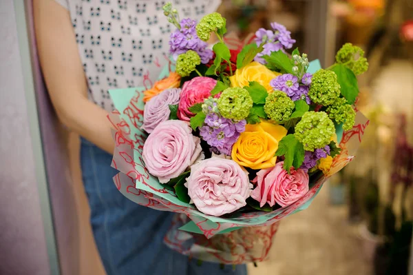Vivid and stylish bouquet of beautiful flowers in woman hands