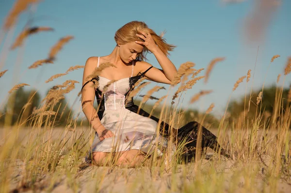 Tenero ritratto di una ragazza bionda in lingerie seduta sul campo — Foto Stock