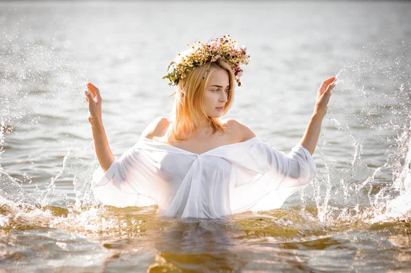 Kadın bir beyaz gömlek ve çiçek çelenk ayakta su ıslak