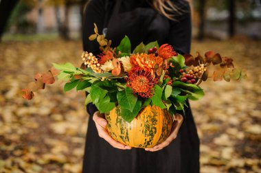 Siyah elbiseli bir kabak çiçekleri ile tutan kadın