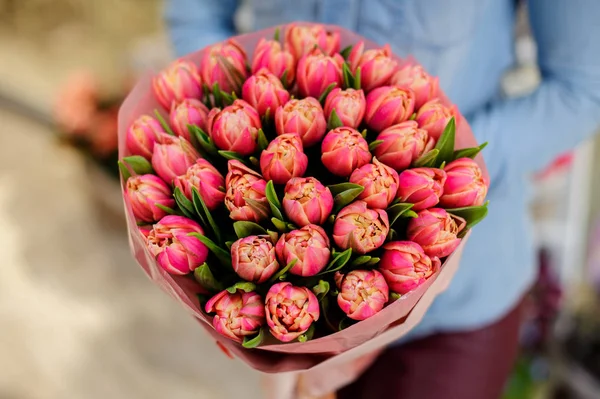 Frau hält einen schönen Strauß rosa Tulpen in der Hand — Stockfoto