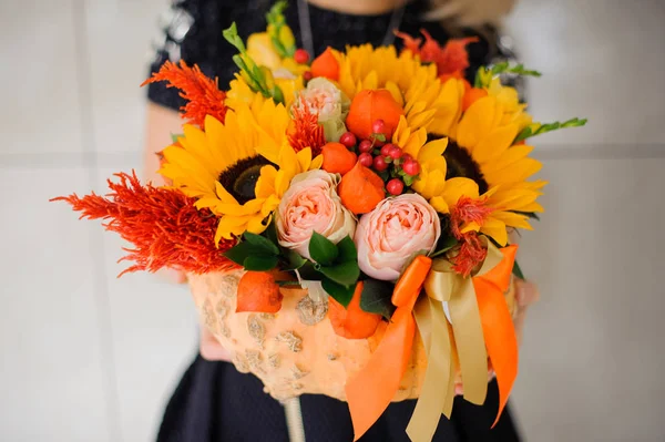 Mulher está segurando um buquê de flores laranja brilhante e colorido — Fotografia de Stock