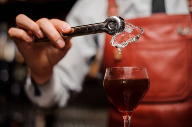 Barmen kokteyl bir buz koyuyor