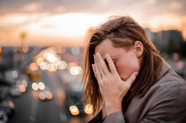 Yüzünü elleriyle kapsayan genç Kızıl saçlı adam