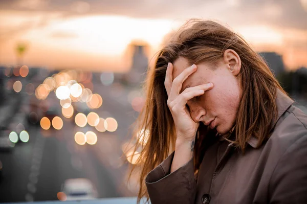Kızıl saçlı ve uzun saçlı genç adam yüz el ile kaplama
