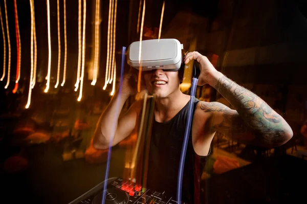 DJ in virtual reality glasses plays the track in club