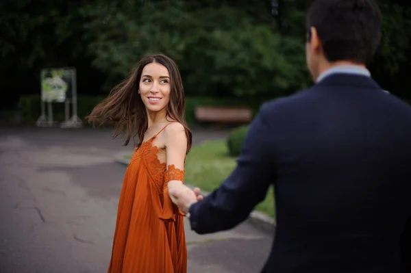 Bakifrån av människan är kostym håller vacker kvinna hand — Stockfoto