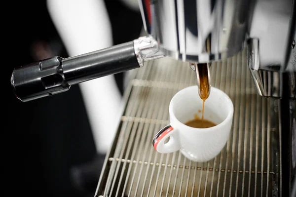 Verser le café de la machine à café dans une petite tasse à café — Photo