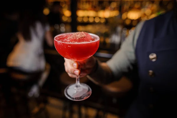 Bartendern håller ett dekorerade glas alkoholhaltiga cocktail — Stockfoto