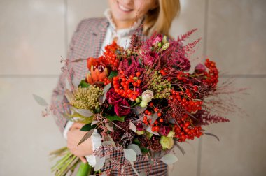 Parlak bir buket çiçek elinde tutan kadın