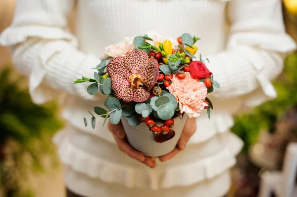 Dama w swetrze gospodarstwa pot z kompozycji piękny kwiat — Zdjęcie stockowe