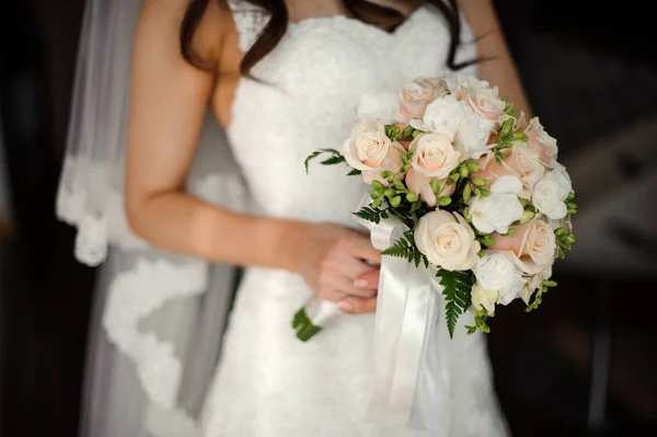 Noiva em um belo vestido branco segurando um buquê — Fotografia de Stock