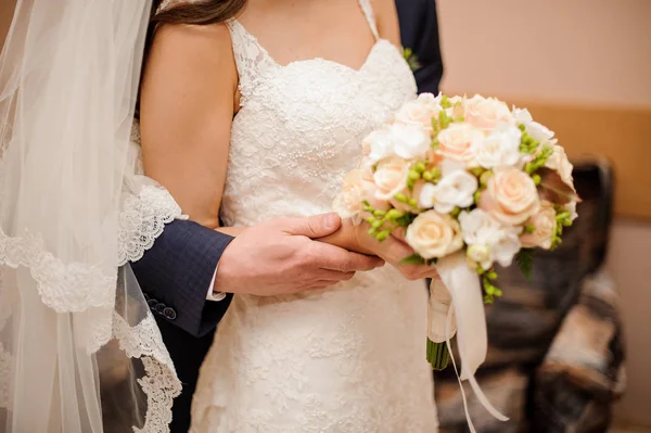 Bräutigam im blauen Anzug umarmt Braut im wunderschönen Brautkleid von hinten — Stockfoto