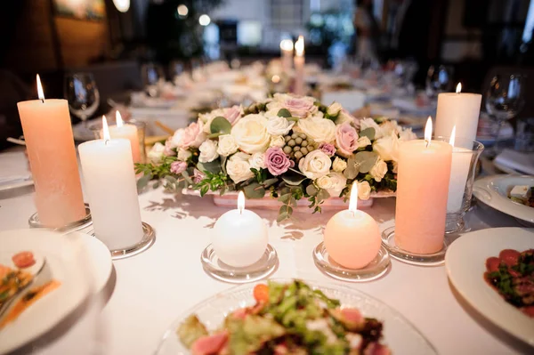 Квіткова композиція, що прикрашає поданий стіл для святкового обіду — стокове фото